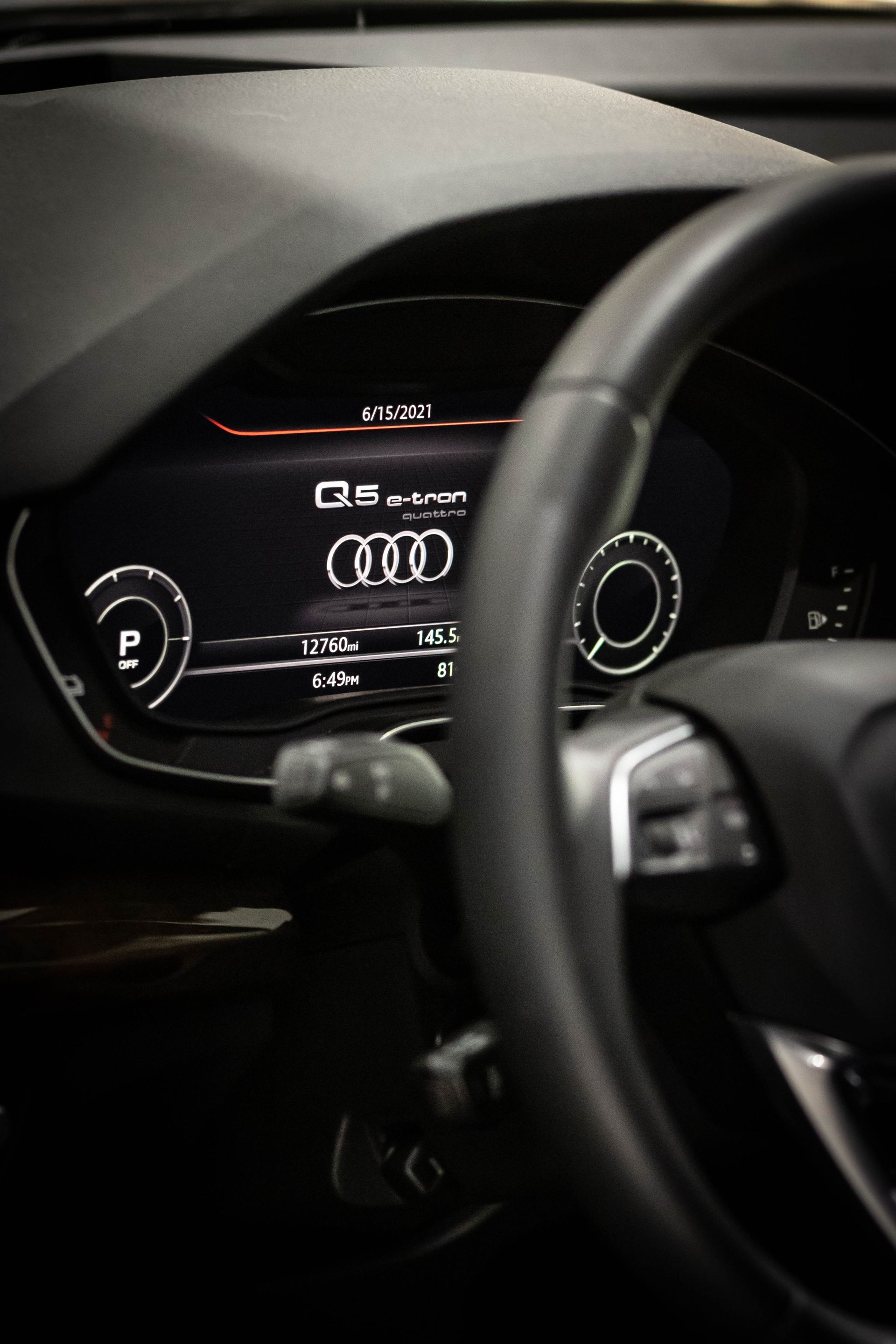 Audi digital dashboard and steering wheel inside a car, showing the speedometer and gauges.