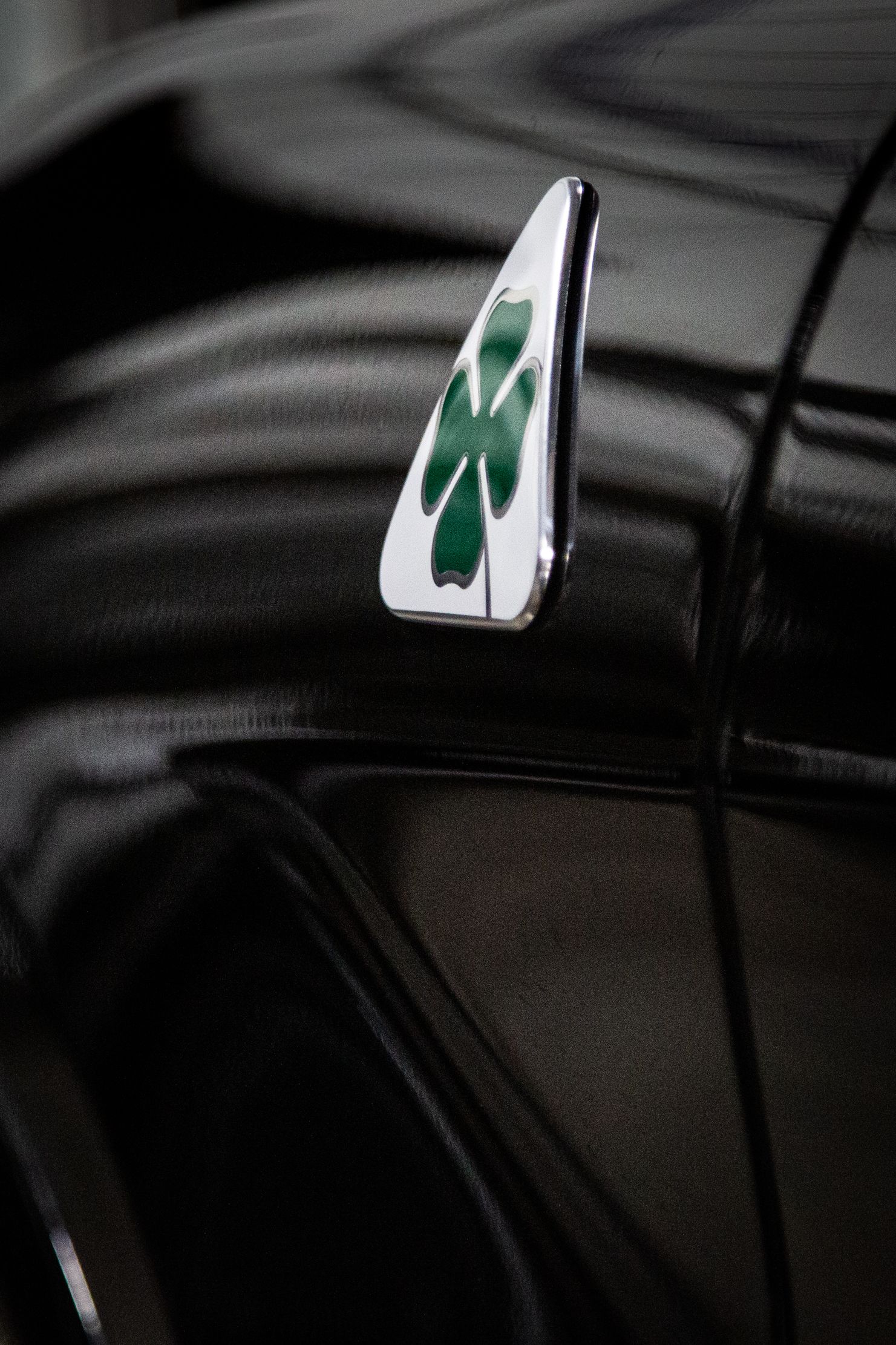 Close-up of a black bag with a small green recycling tag clipped to it