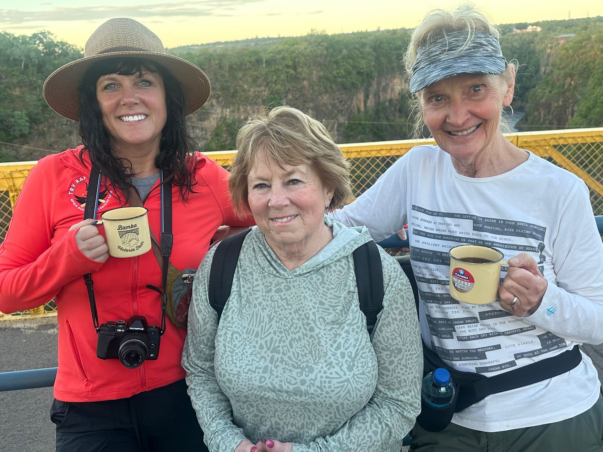 Two women are standing next to each other on a bridge.