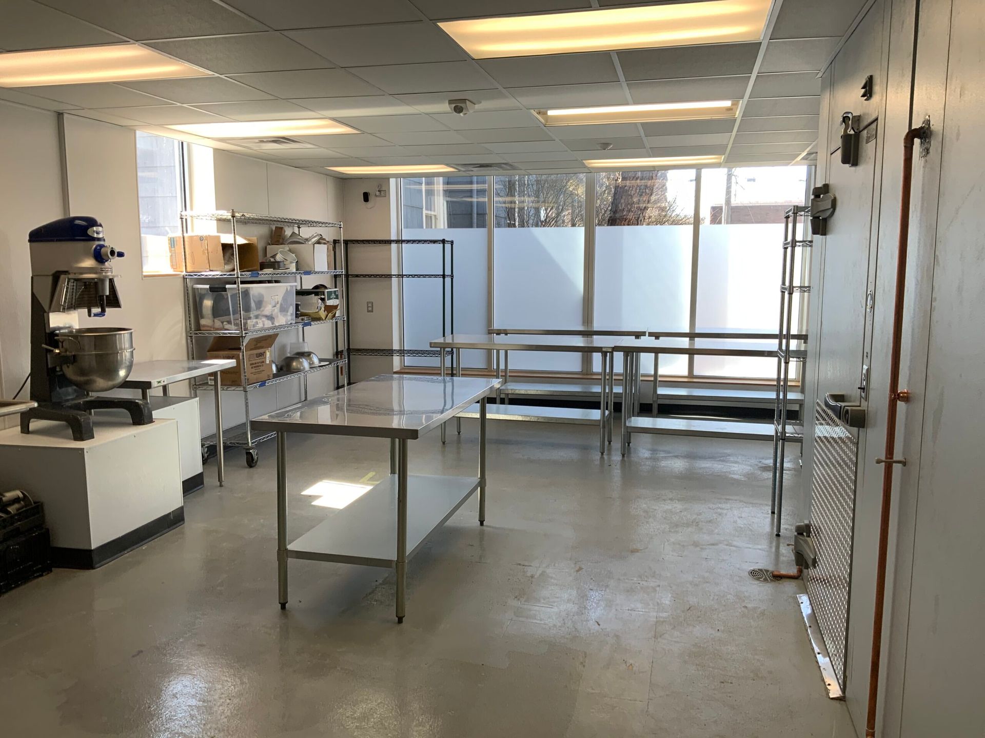 A large empty room with a lot of shelves and tables.