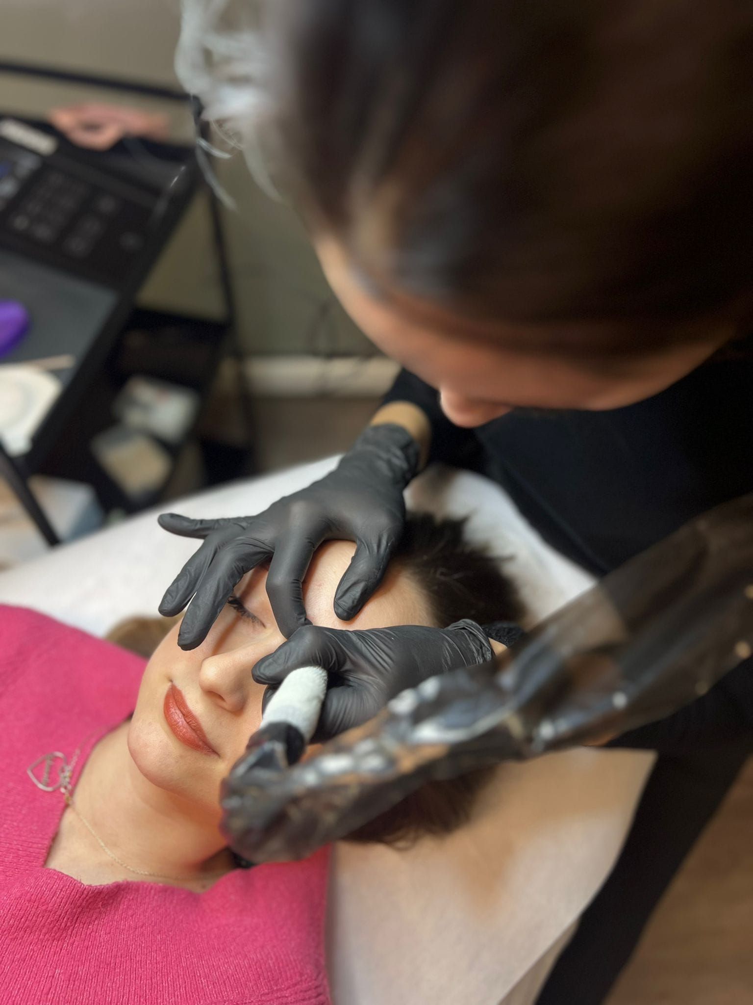 Una donna si sta facendo un tatuaggio sulle sopracciglia.