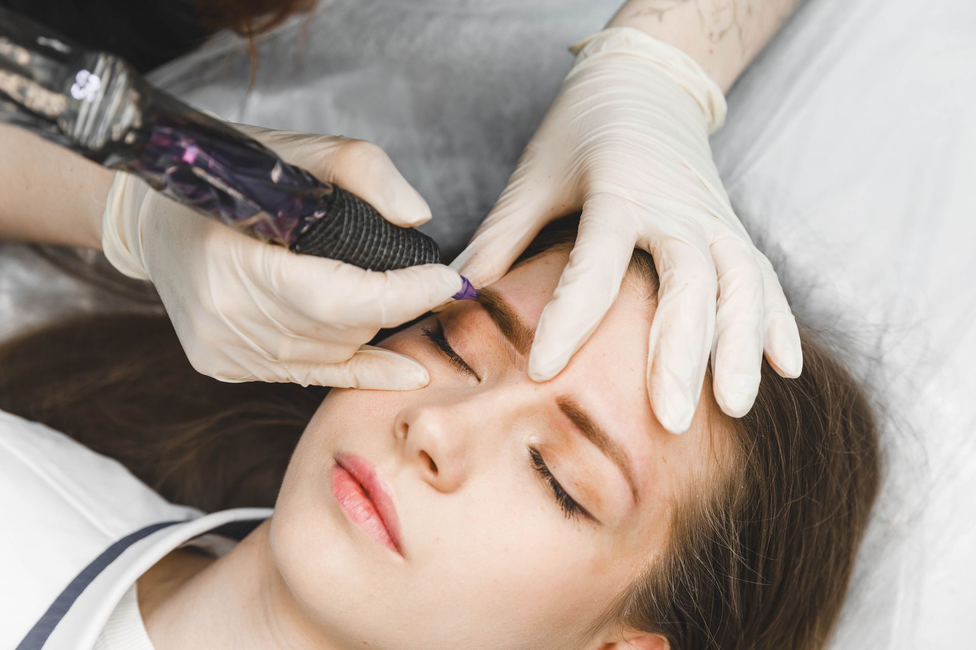 Una donna si sta facendo un tatuaggio sulle sopracciglia.