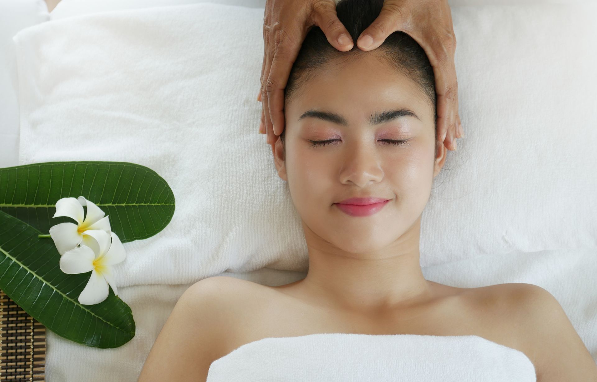 Una donna si sta facendo fare un massaggio alla testa in una spa.