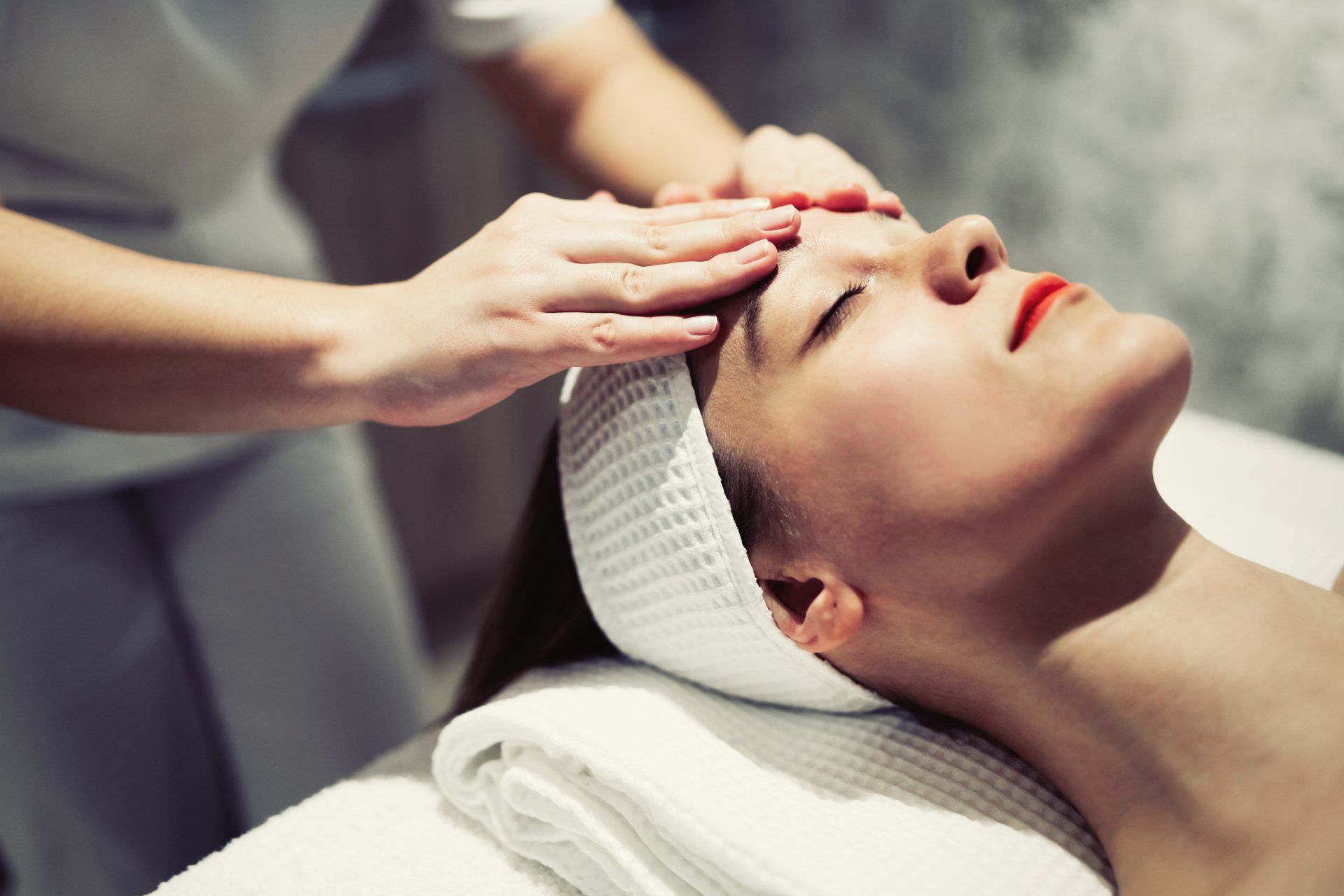 Una donna si sta sottoponendo a un massaggio facciale in una spa.