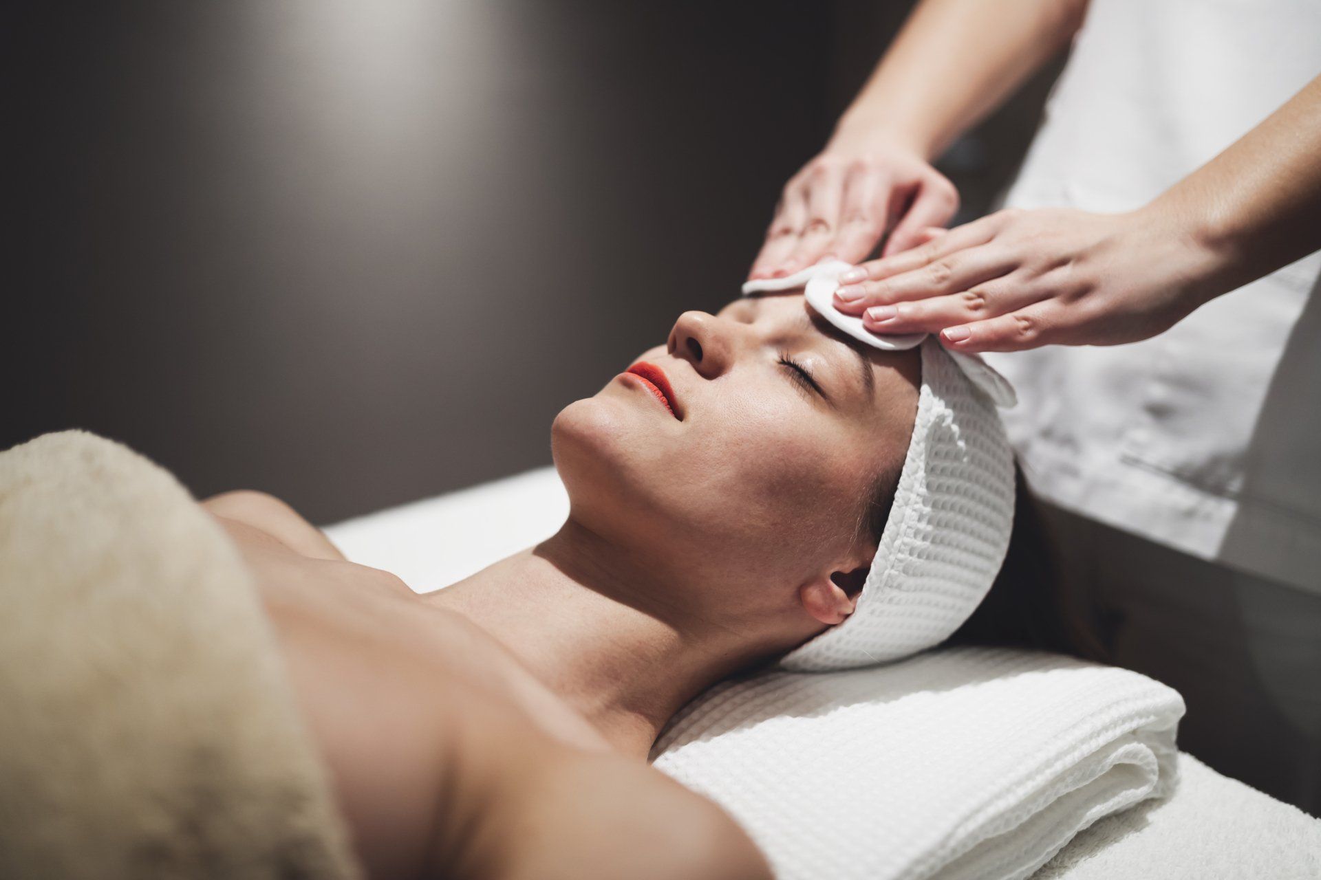 una donna sta ricevendo un massaggio al viso in un salone di bellezza .