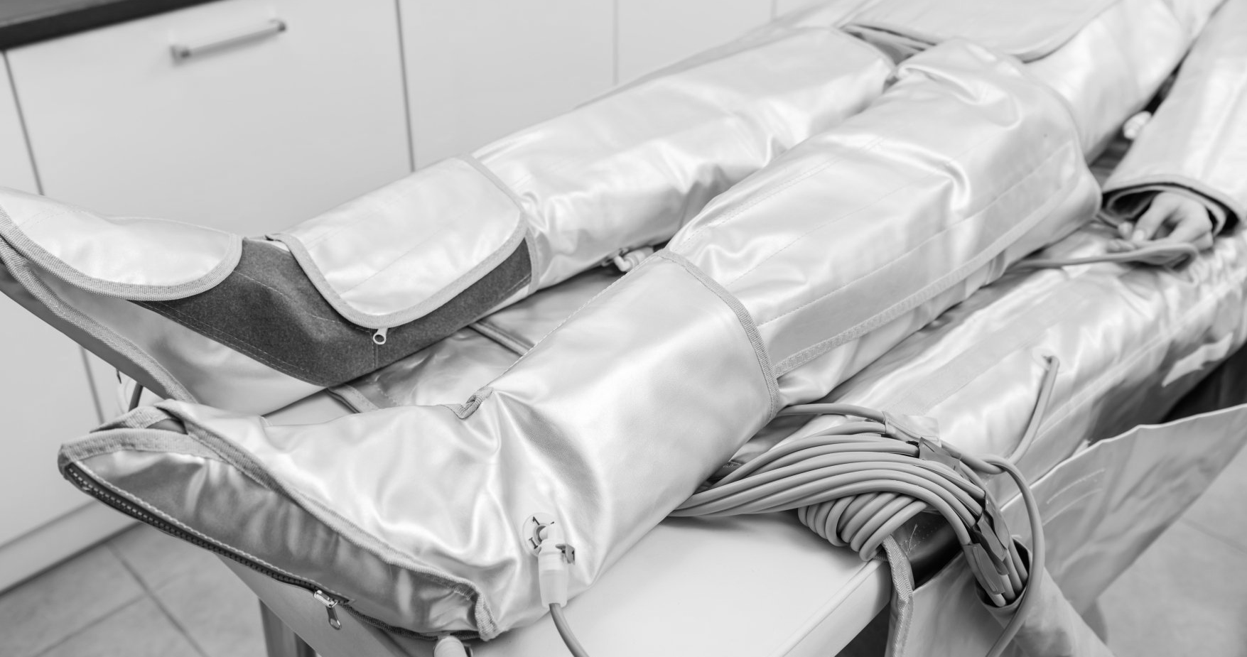 Una persona è sdraiata su un tavolo con le gambe avvolte in una coperta argentata.