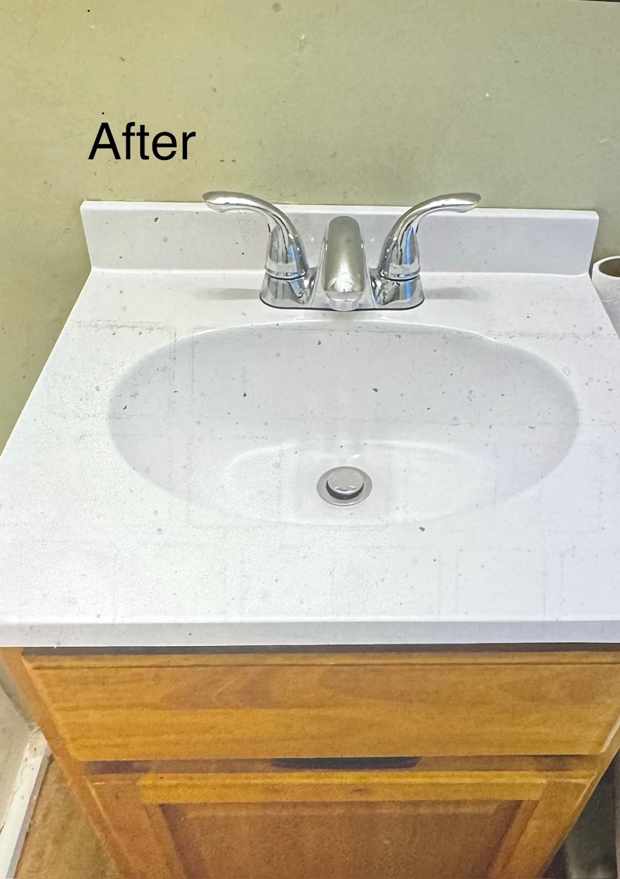 White bathroom sink with chrome faucet on wooden cabinet.