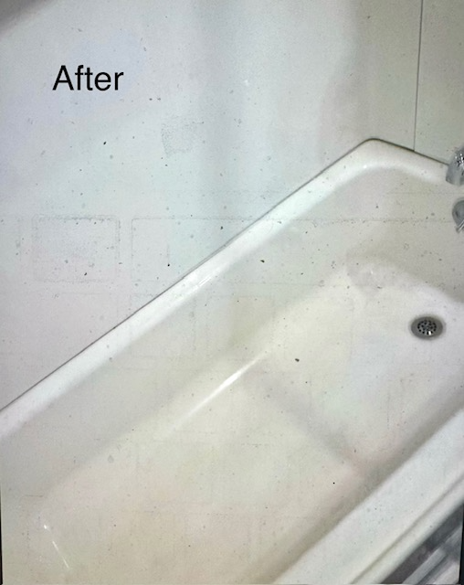 Clean, white bathtub after cleaning. Corner setting, with drain visible.