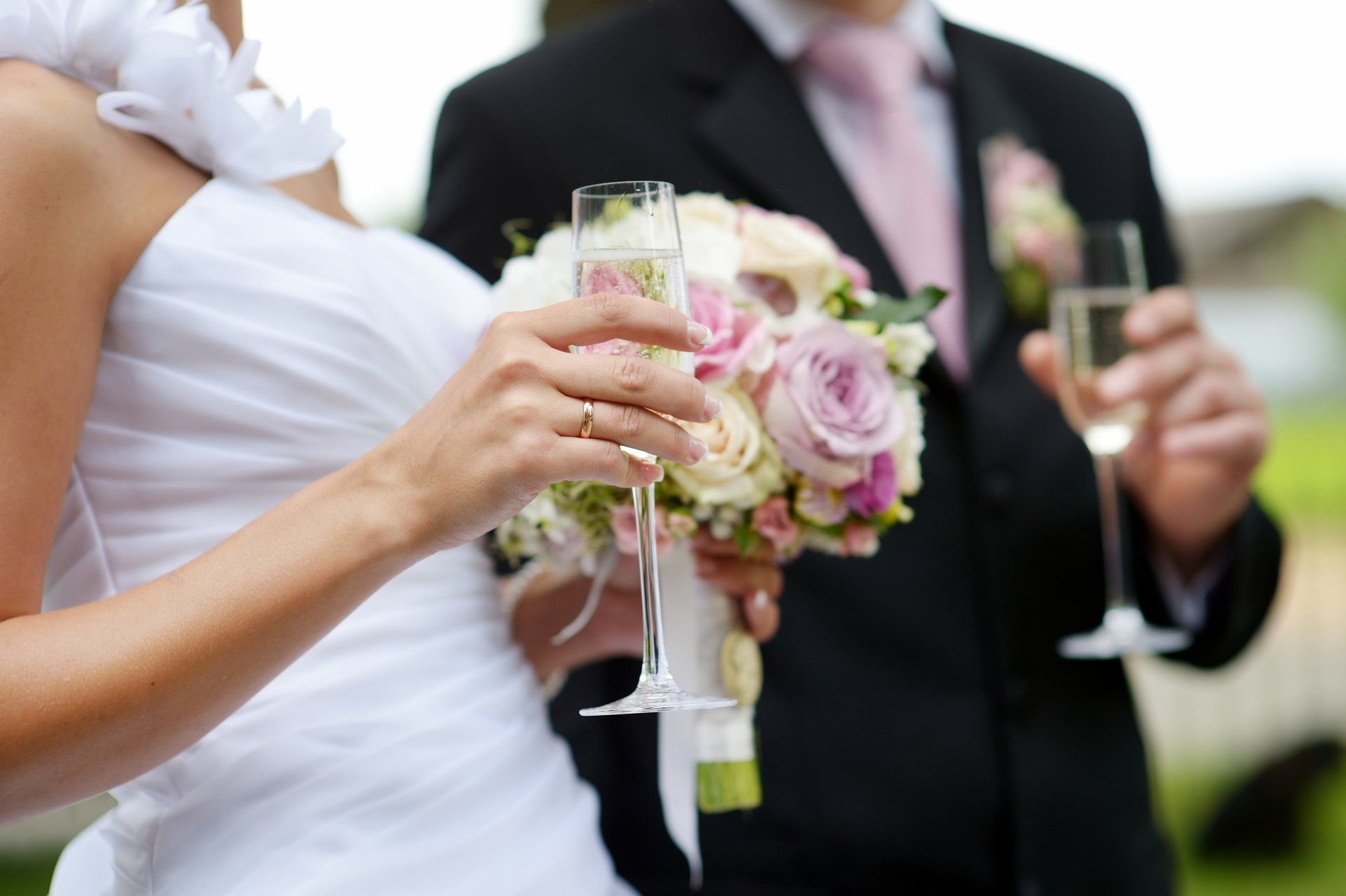 sposa con flute di spumante e bouquet in mano