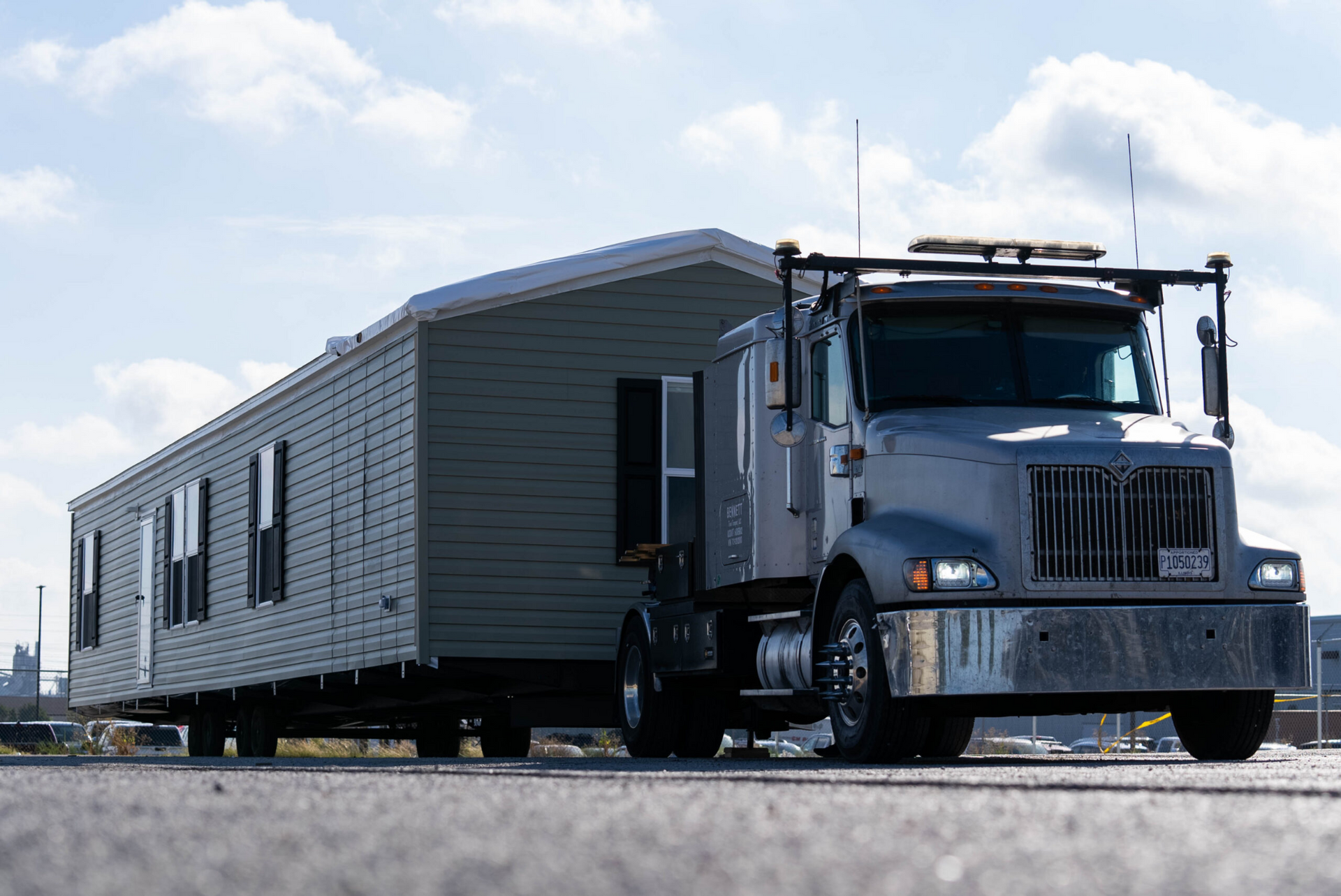 “Semi-truck transporting a manufactured home to its installation site for residential setup.”
