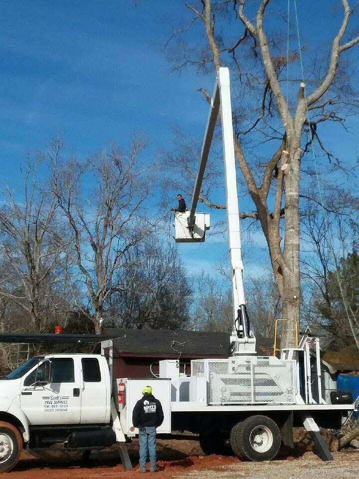 Utility truck with bucket lift and a worker outdoors under a blue sky