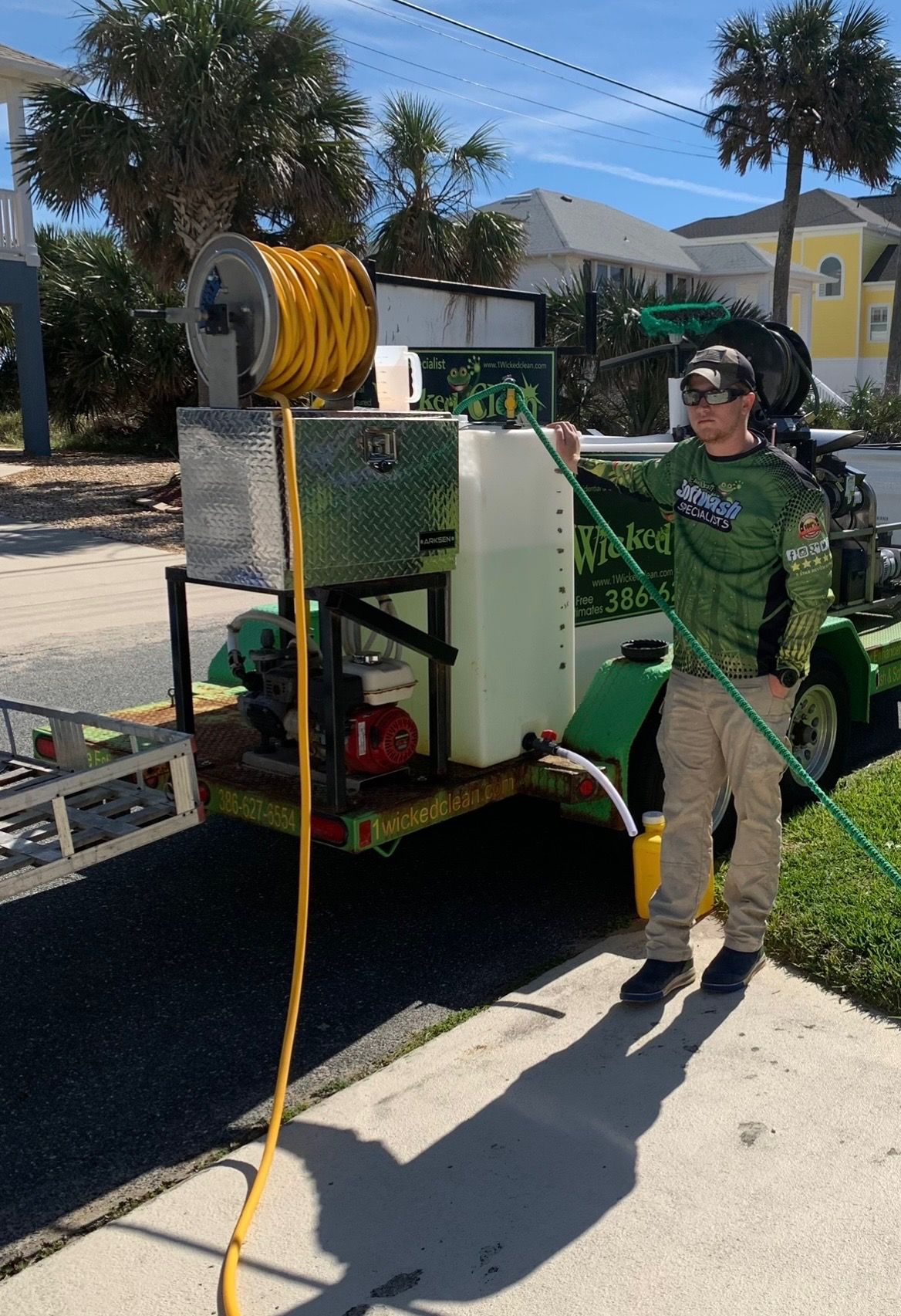 Technician soft washing a stucco home exterior in Ormond Beach, Florida.