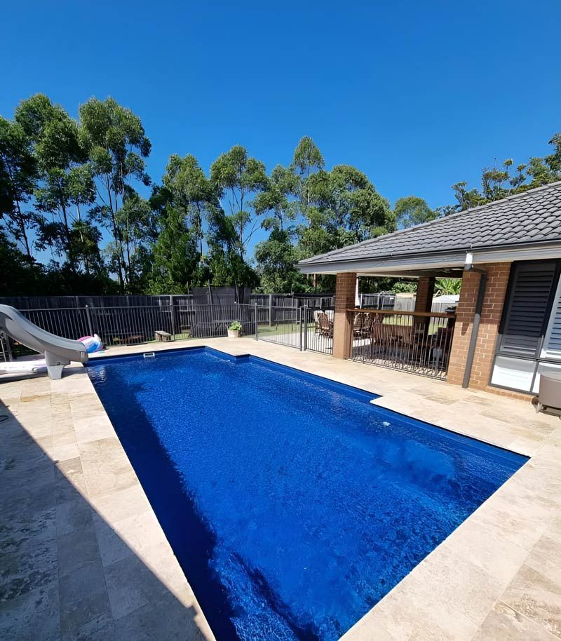 A Large Swimming Pool With A Slide In The Backyard Of A House 
— Pool Zone in Port Macquarie, NSW