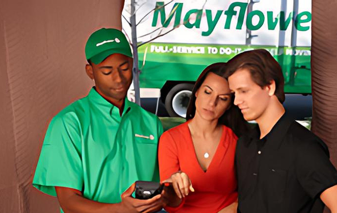 A man in a green shirt is standing next to a woman and a man in a black shirt