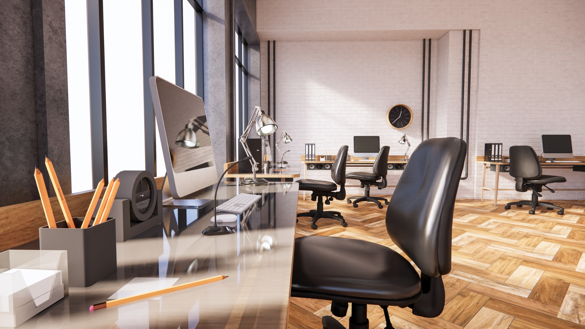 An office with a lot of desks and chairs and a wooden floor.