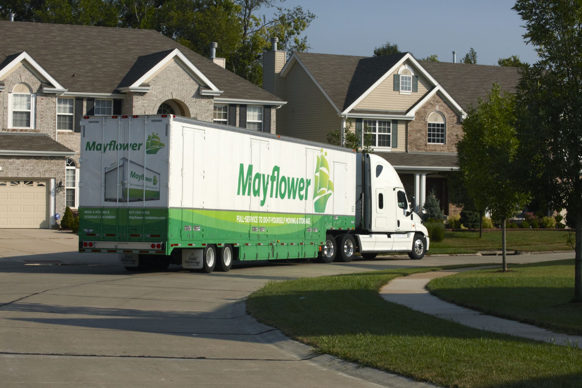 A mayflower moving truck is parked in front of a house