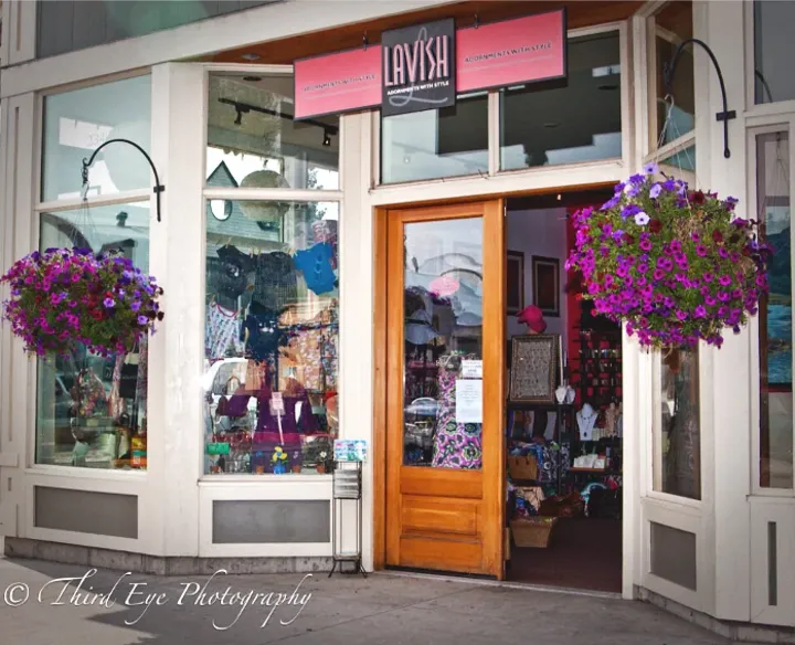 A store front with purple flowers and a sign that says lavish
