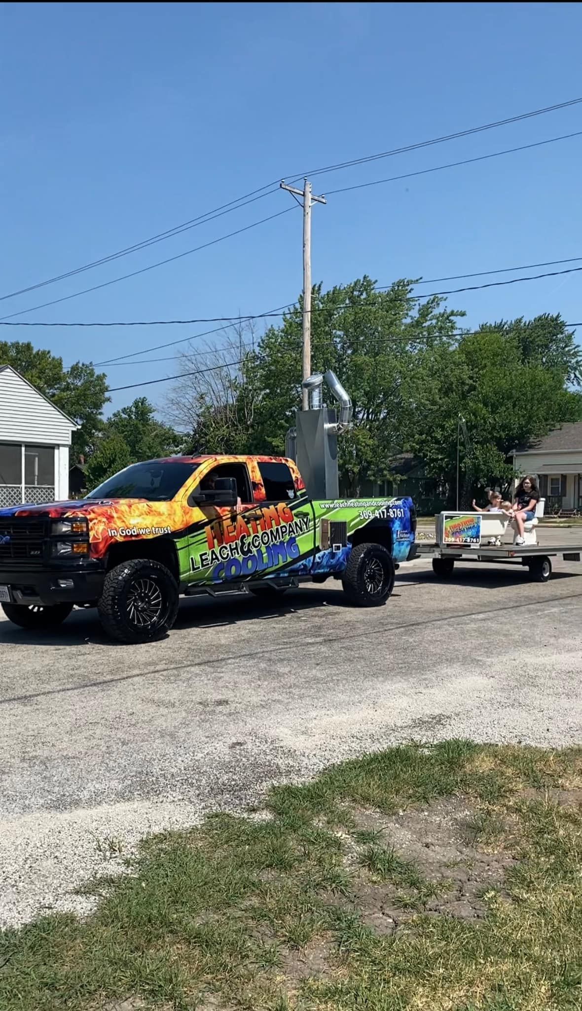 A colorful truck is parked on the side of the road next to a picnic table.