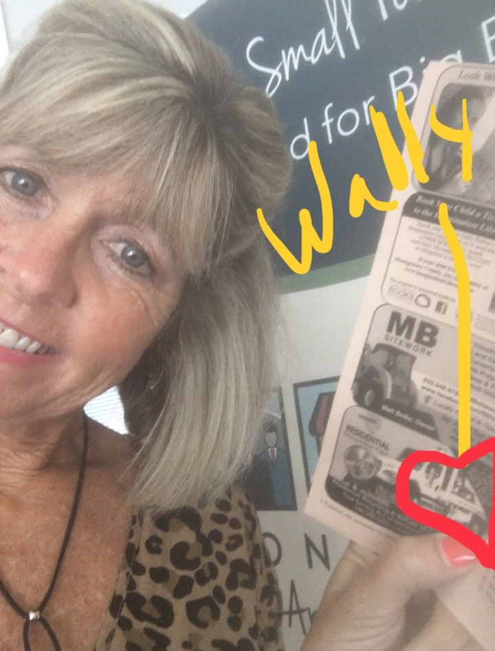 A woman is holding a newspaper that says small d for walls