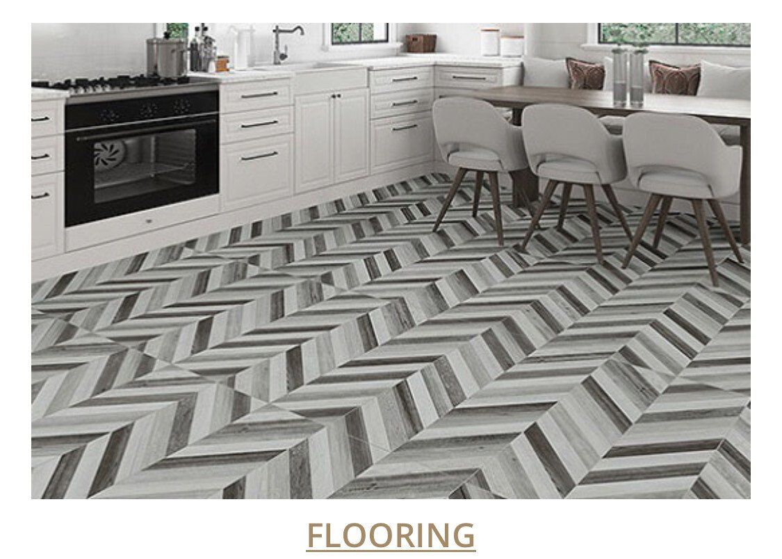 Kitchen with herringbone patterned gray flooring. White cabinets and table.