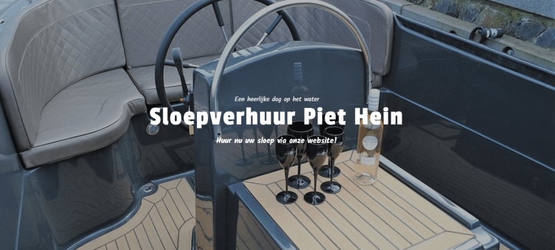 Het interieur van een gestroomlijnde, donkergrijze boot met beige dek, voorzien van een stuurwiel en een tafel gedekt met wijnglazen.