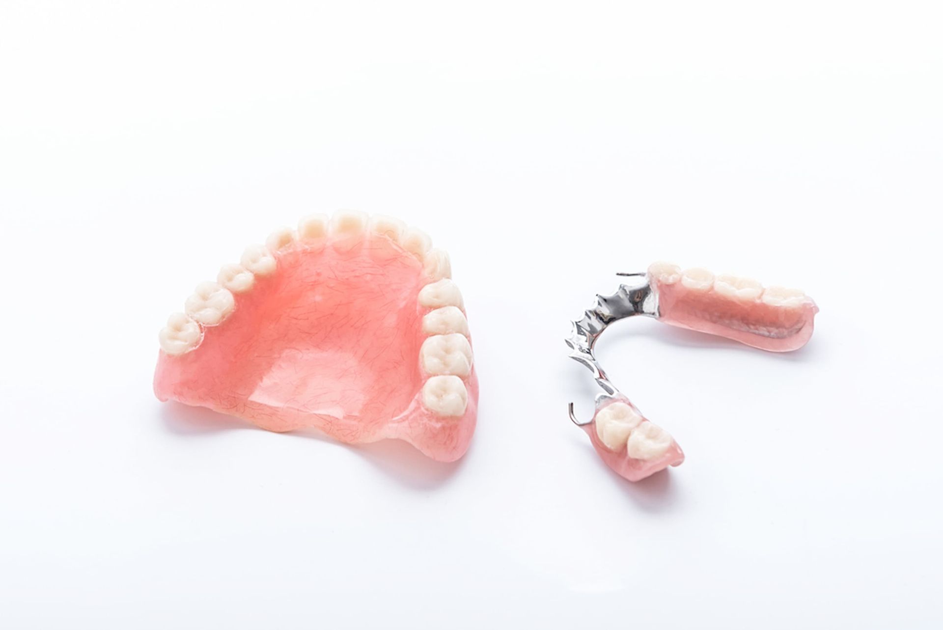 A Denture and A Partial Denture on A White Background — Cane to Coast Dentures in Sarina, QLD
