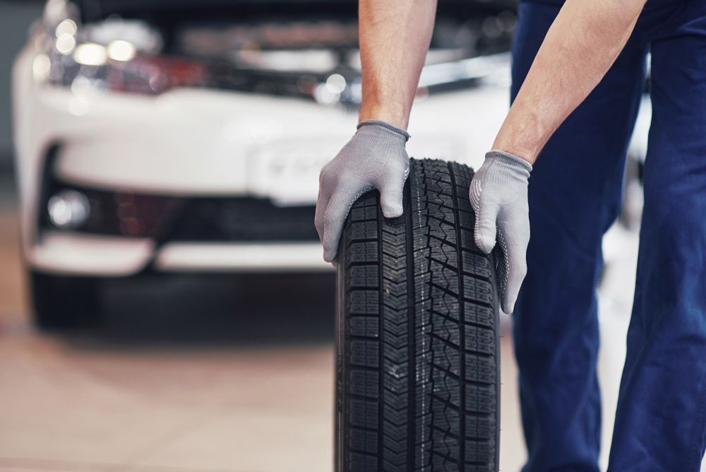 Mechanic Holding A Tire — Mechanic In Noosaville, QLD