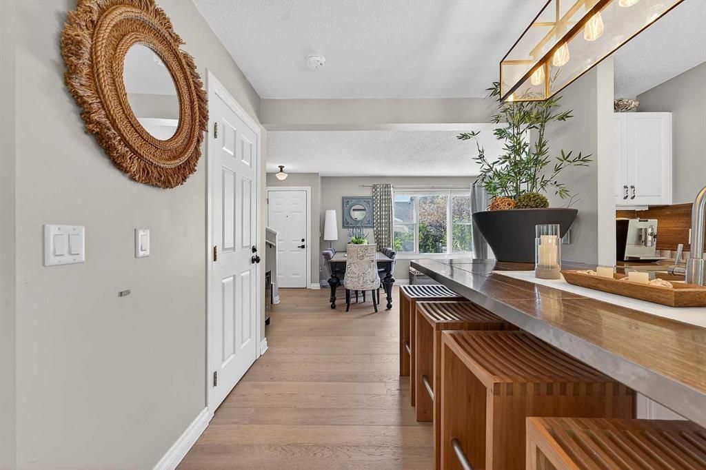 Bright open kitchen with long island, wood stools, and view into a dining area and patio doors.