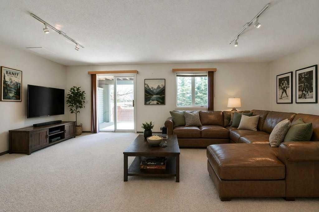 Bright living room with beige sectional sofa, TV, coffee table, and sliding glass door.