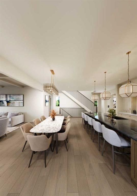 Bright modern open-plan dining room with long table, bar stools, pendant lights, and staircase.
