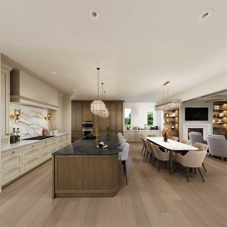 Modern open-plan kitchen and dining room with wood island, white cabinetry, and long table by the fireplace.