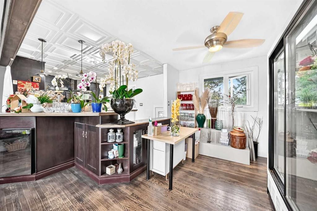 Bright flower shop interior with plants, gift displays, and a glass cooler on the right
