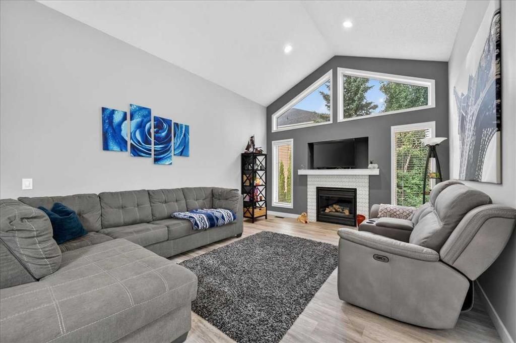 Bright modern living room with gray sectional, recliner, fireplace, and large windows.