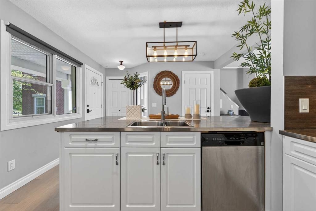 Bright modern kitchen with white cabinets, gray walls, island, and large windows