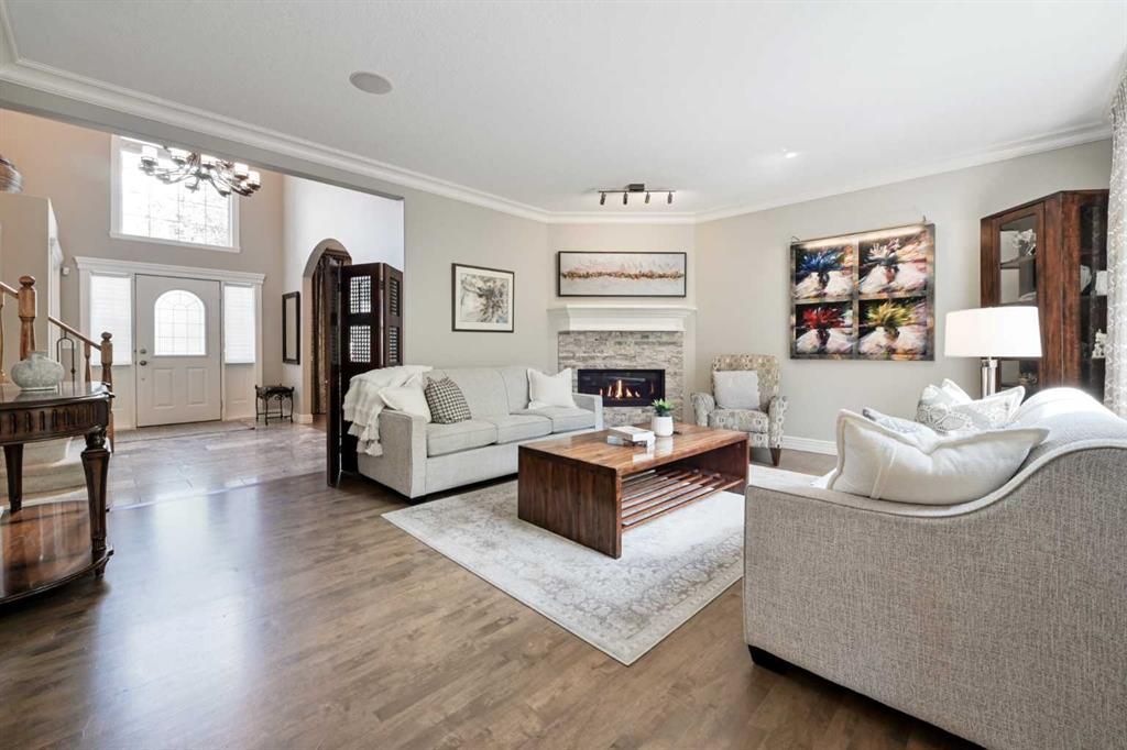 Bright living room with beige sofas, wooden coffee table, rug, and hardwood floors