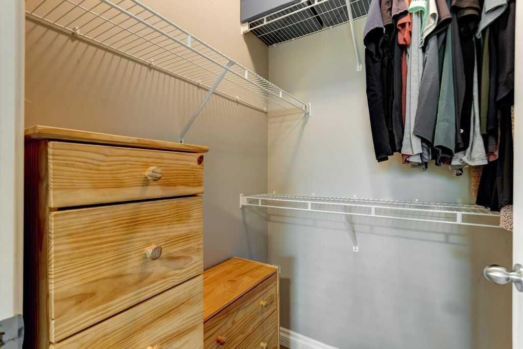 Bathroom with white shower curtain, toilet, vanity, and mirror under bright overhead lights.