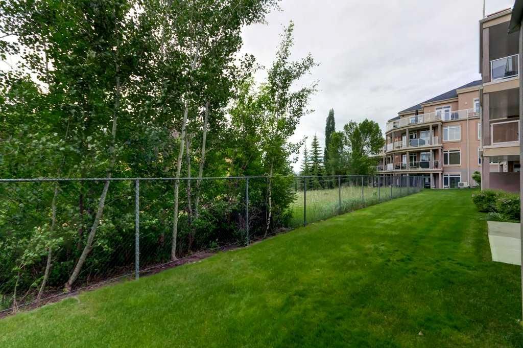 Apartment patio with glass doors, bench seating, and a grassy yard