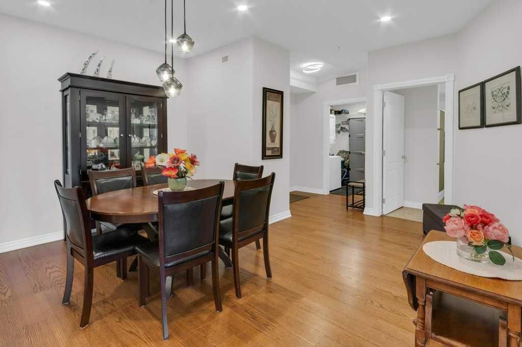 Bright dining room with dark wood table, chairs, flowers, and hardwood floors in a modern open space