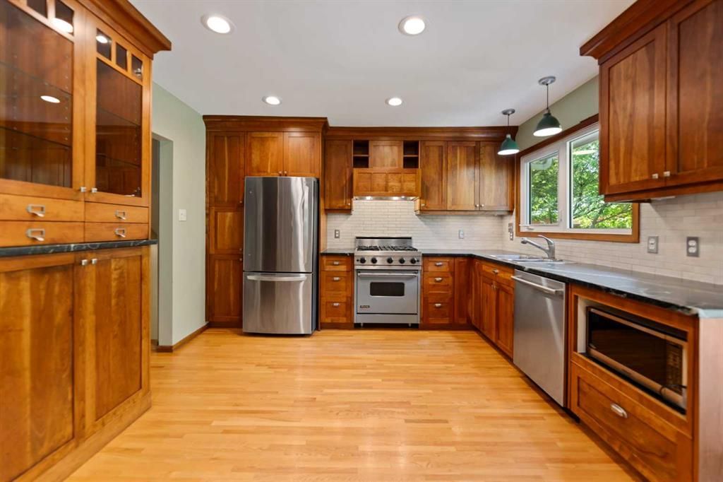 Spacious modern kitchen with wood cabinets, stainless steel appliances, and hardwood floors