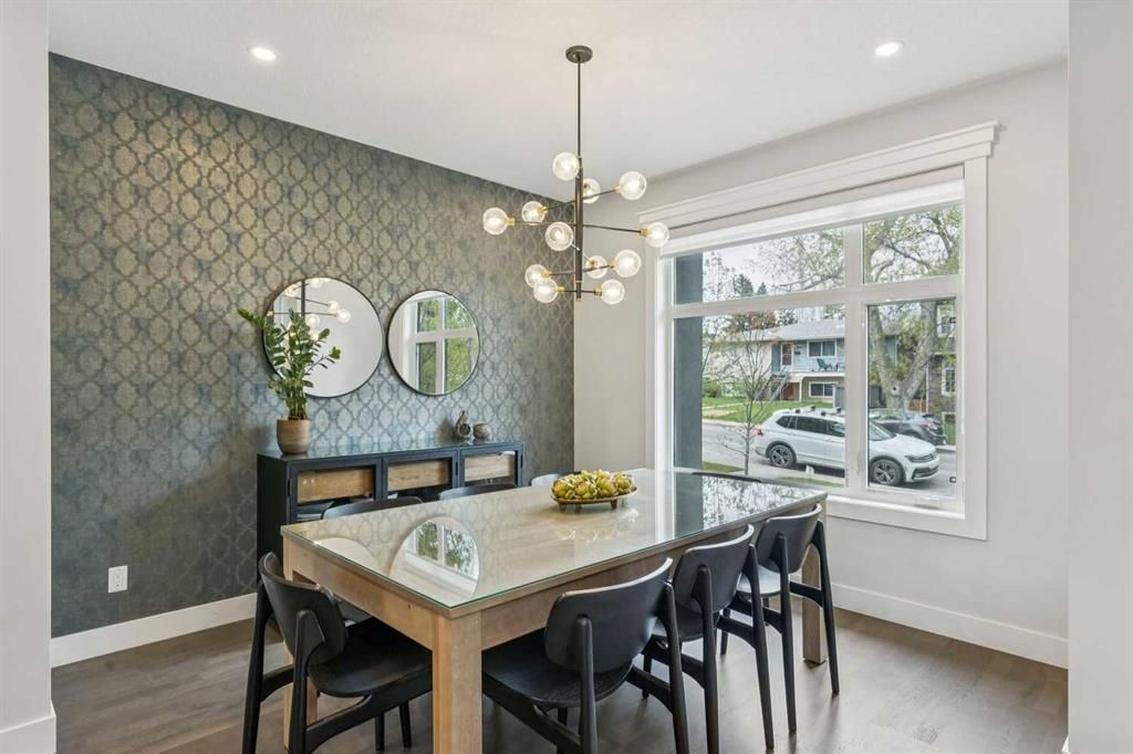 Modern dining room with a marble table, black chairs, patterned wall, and large window