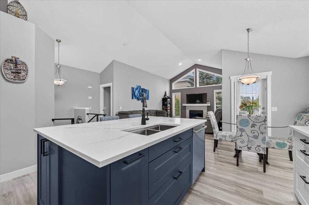 Modern kitchen with navy island, white countertops, and a dining area near large windows