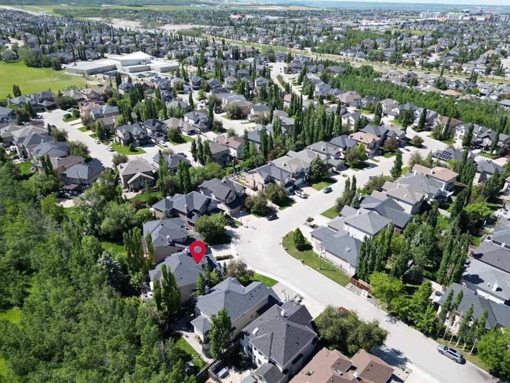 Aerial view of a suburban neighborhood with houses, trees, and curving streets on a sunny day
