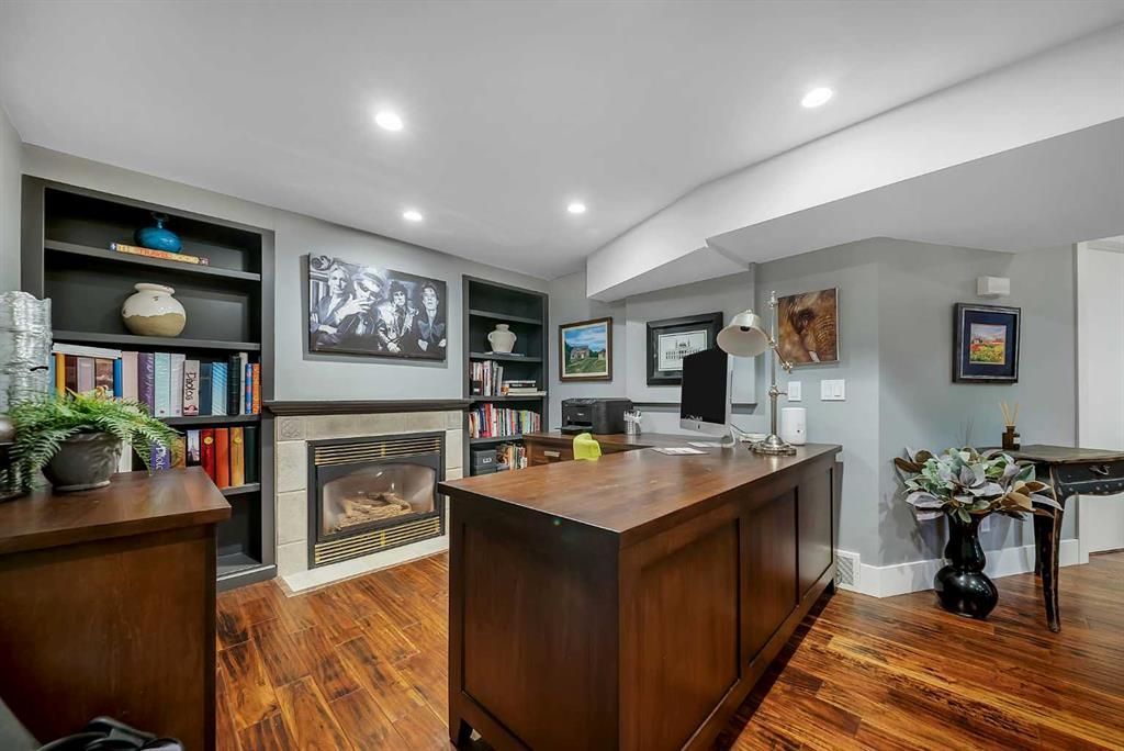 Modern kitchen with dark wood island, hardwood floors, and fireplace in an open living space