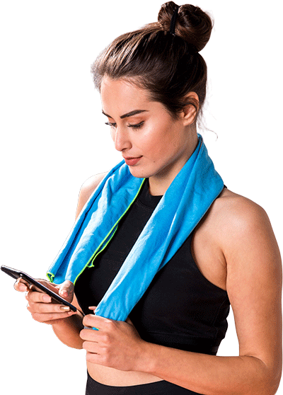 A woman with a blue towel around her neck is looking at her phone.