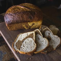 Loaf of rustic bread with several sliced pieces on a wooden cutting board