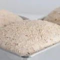 Loaf of rustic bread with several sliced pieces on a wooden cutting board