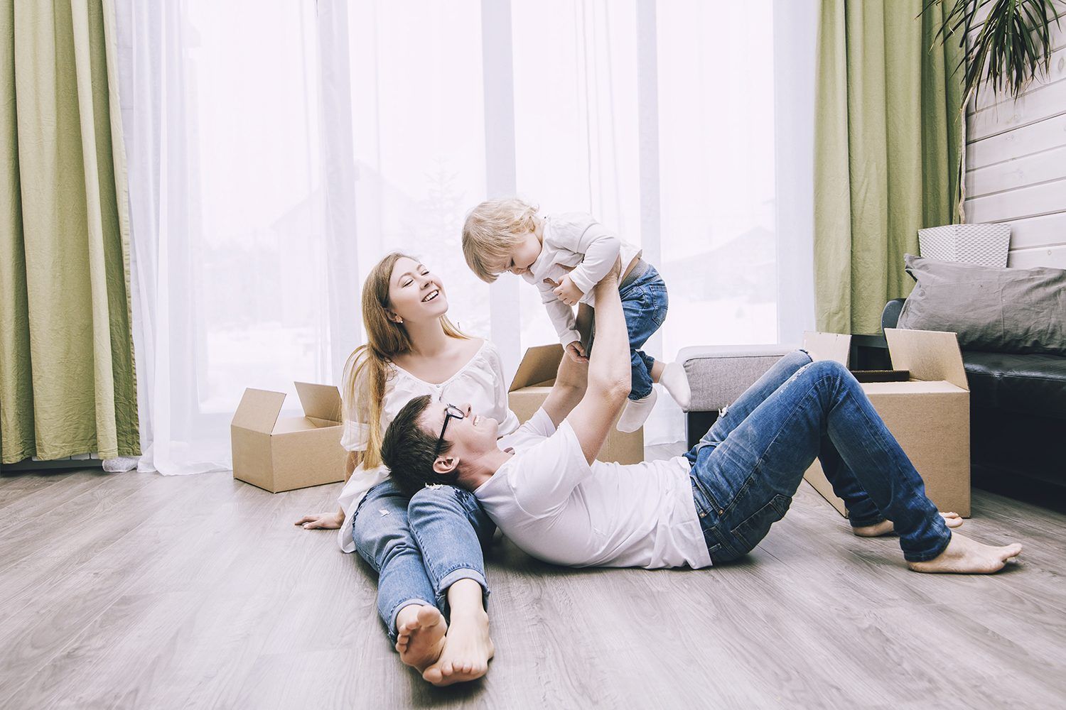 A man is laying on the floor holding a child in his arms.