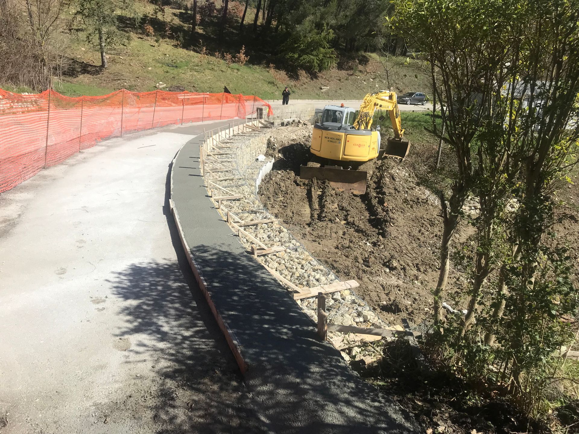 Un escavatore giallo è parcheggiato sul ciglio della strada.