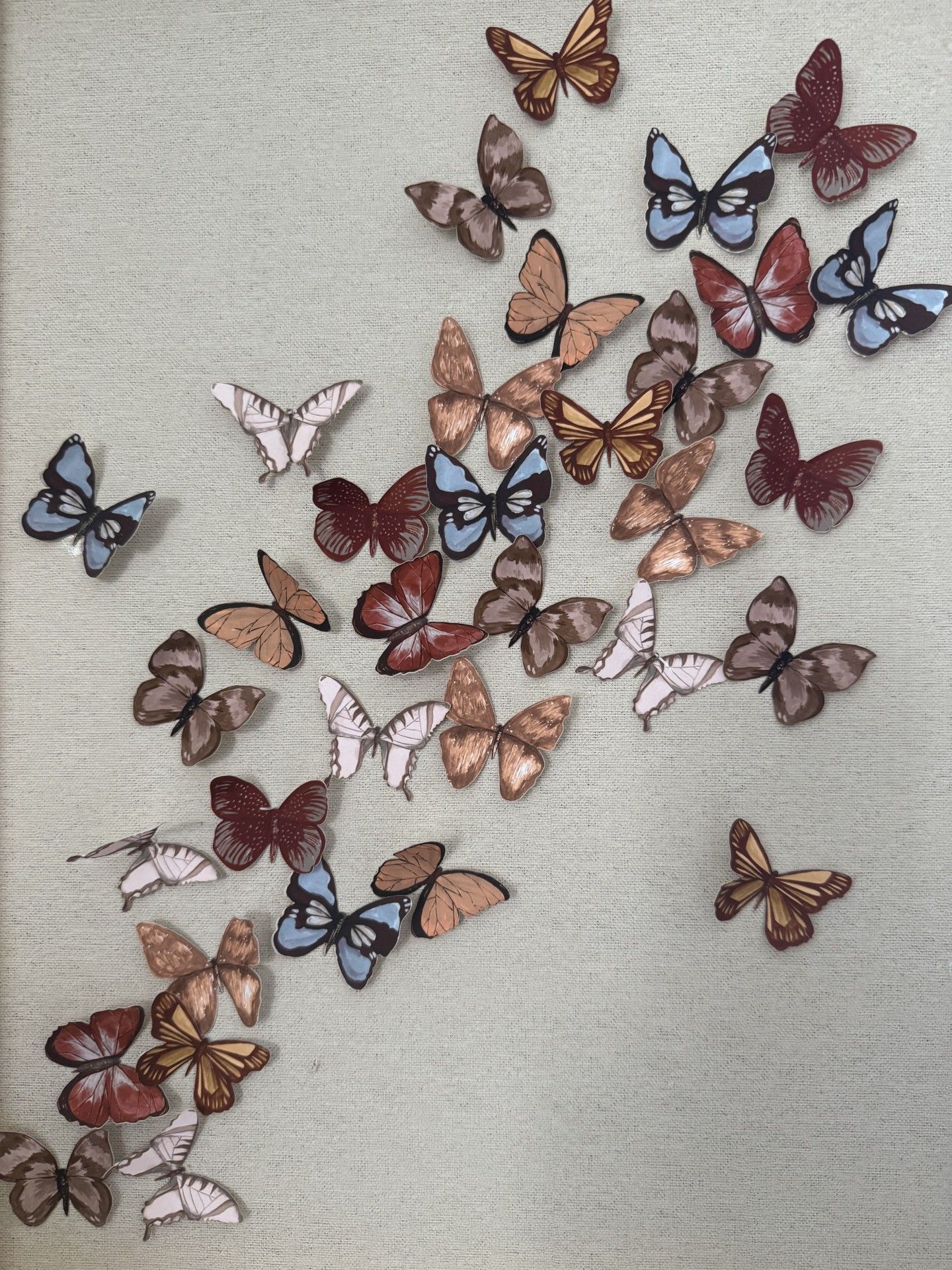 Butterflies of various colors scattered on a light green textured surface.