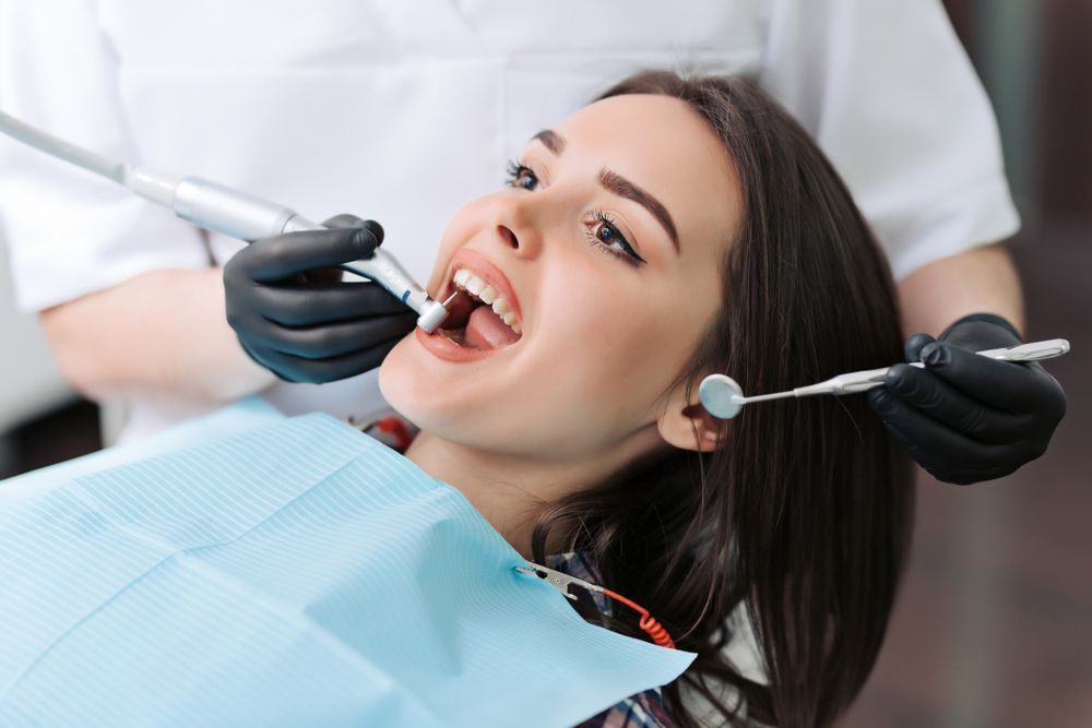 A Woman is Having Her Teeth Examined by a Dentist — Graham Johnson Dental Surgery In Beresfield, NSW
